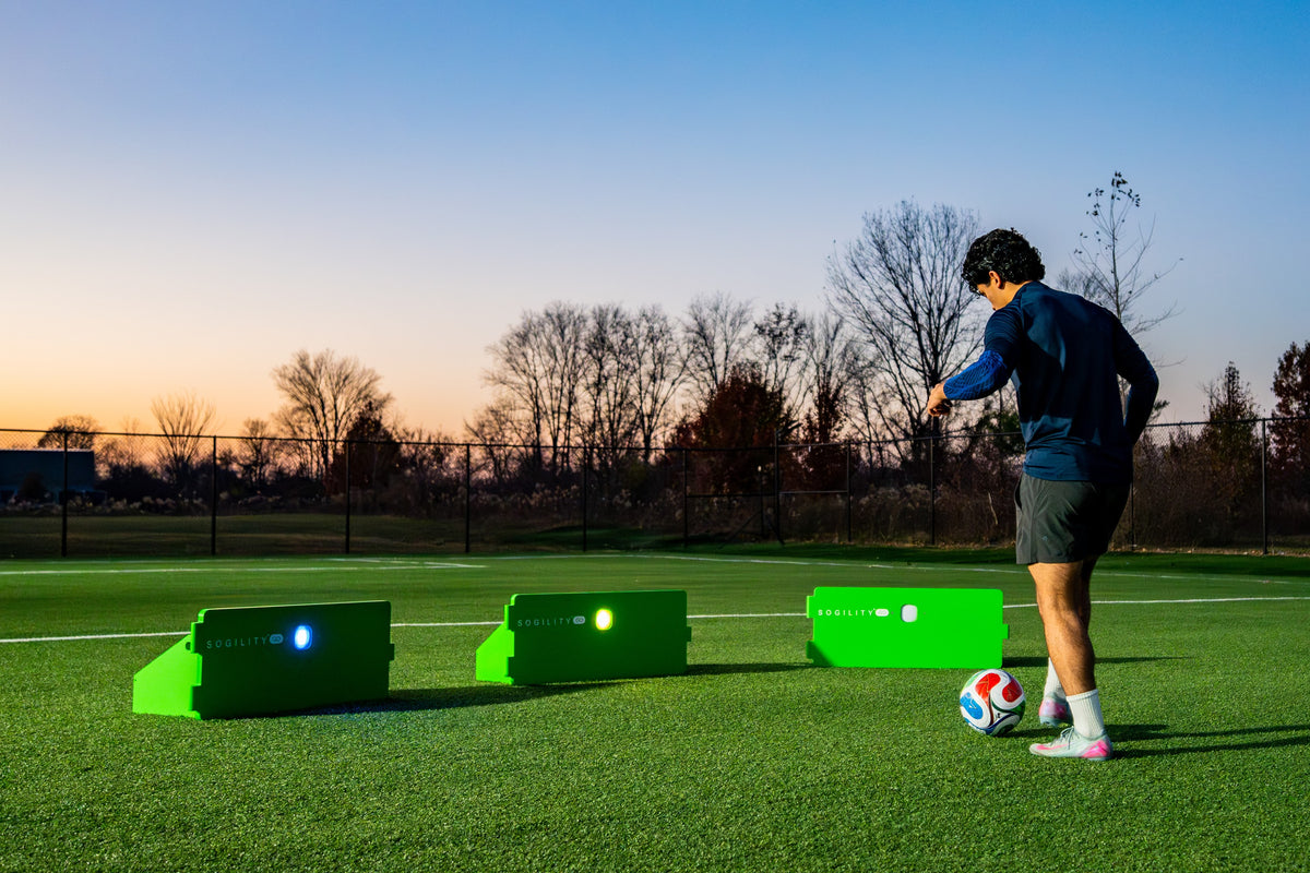 Player training at dusk with three ReboundIQ boards and glowing Impact Lights