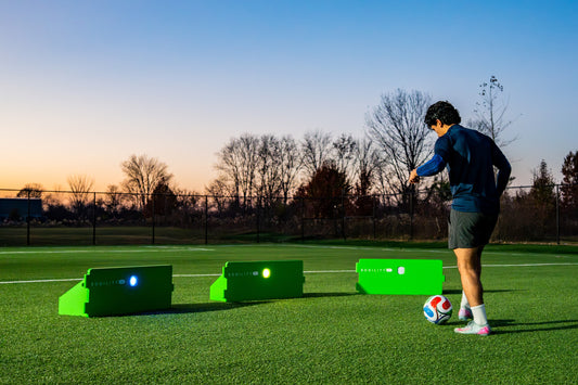 Player training at dusk with three ReboundIQ boards and glowing Impact Lights